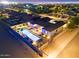 Night aerial view of a home showcasing a lit pool, a covered patio and backyard landscaping at 3125 W Desert Ln, Laveen, AZ 85339