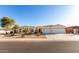Attractive home exterior with a well-kept lawn, mature trees, and a spacious three-car garage at 3125 W Desert Ln, Laveen, AZ 85339