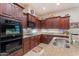 Well-appointed kitchen features granite counters, tile backsplash, and dark wood cabinets at 3125 W Desert Ln, Laveen, AZ 85339