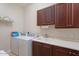 Well-lit laundry room featuring a sink, wood cabinets, and a modern washer and dryer at 3125 W Desert Ln, Laveen, AZ 85339