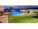 Outdoor space with a pool, hammock, and manicured artificial grass at 3125 W Desert Ln, Laveen, AZ 85339