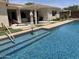 Inviting backyard pool with covered patio and lounge area offers the perfect space for relaxation and outdoor entertaining at 3125 W Desert Ln, Laveen, AZ 85339