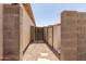 Backyard access with gravel, pavers, a storage shed, and block wall fencing at 318 E Taylor Trl, San Tan Valley, AZ 85143