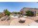 Lush backyard with pool, lounge area, fire pit, desert landscaping, and palm trees at 318 E Taylor Trl, San Tan Valley, AZ 85143