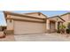 Exterior view of a one-story home featuring a two-car garage, front entryway, and low-maintenance landscaping at 318 E Taylor Trl, San Tan Valley, AZ 85143