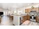 Well-lit kitchen with stainless steel appliances, wood cabinets, and views of the living and dining areas at 318 E Taylor Trl, San Tan Valley, AZ 85143