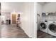 Hallway leading to a laundry room with white washer and dryer and a shelf for laundry supplies at 318 E Taylor Trl, San Tan Valley, AZ 85143