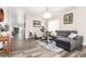 Bright living room with wood floors, a gray sectional sofa, and natural light at 318 E Taylor Trl, San Tan Valley, AZ 85143