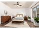 Comfortable main bedroom features natural lighting, neutral tones, ceiling fan, and wood flooring at 318 E Taylor Trl, San Tan Valley, AZ 85143