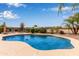 Inviting backyard pool with crystal-clear water, surrounded by manicured landscaping and mature palm trees at 318 E Taylor Trl, San Tan Valley, AZ 85143