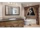 Elegant bathroom featuring an ornate mirror, decorative vanity and a bathtub with curtain at 3413 E Equestrian Trl, Phoenix, AZ 85044