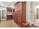 A spacious walk-in closet boasts custom wooden built-ins, drawers, and ample storage and hanging space at 3413 E Equestrian Trl, Phoenix, AZ 85044
