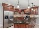 Basement kitchenette with granite countertops, stainless fridge and dark wood cabinetry at 3413 E Equestrian Trl, Phoenix, AZ 85044