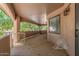 Covered patio with ceiling fan, stone pillars, and railing overlooking the landscaped backyard at 3413 E Equestrian Trl, Phoenix, AZ 85044