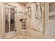 An elegant shower with glass enclosure and unique tile work and a shower caddy, featuring bronze hardware at 3413 E Equestrian Trl, Phoenix, AZ 85044