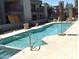 Sparkling community pool surrounded by lush landscaping and lounge seating at 3420 W Danbury Dr # C130, Phoenix, AZ 85053
