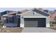 A single-story home with a gray exterior, two-car garage, desert landscaping, and a mountain backdrop at 35500 N Common Ct, San Tan Valley, AZ 85140