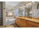 Bright bathroom featuring a double vanity with a light wood finish, granite countertop, and soaking tub at 4055 N Recker Rd # 71, Mesa, AZ 85215