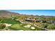 Breathtaking aerial of a golf course community nestled in the mountains with clubhouse and desert landscape at 42145 N Fairgreen Ct, Anthem, AZ 85086