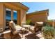 Cozy back patio with comfortable chairs, a small table, and desert views through the windows at 42145 N Fairgreen Ct, Anthem, AZ 85086