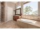 Well-lit bathroom with a soaking tub, a walk-in shower, and stunning outdoor views at 42145 N Fairgreen Ct, Anthem, AZ 85086