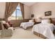 Bedroom features twin beds, carpeted floor, and views out of a large window at 42145 N Fairgreen Ct, Anthem, AZ 85086