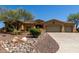 Desert home with a three-car garage, mature desert landscaping, and a stone and rock garden at 42145 N Fairgreen Ct, Anthem, AZ 85086