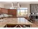 Elegant kitchen island boasts marble countertops, modern pendant lighting and scenic desert view at 42145 N Fairgreen Ct, Anthem, AZ 85086