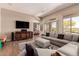 Bright living area with comfortable seating, sleek media console, and scenic views from the sliding glass doors at 42145 N Fairgreen Ct, Anthem, AZ 85086