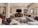 Open-concept living room with stylish decor, a contemporary sofa, and a view into the formal dining area at 42145 N Fairgreen Ct, Anthem, AZ 85086