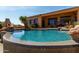 A beautiful blue swimming pool is surrounded by rocks and desert landscaping in backyard at 42145 N Fairgreen Ct, Anthem, AZ 85086