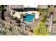 Aerial view of a beautiful backyard pool with stone accents and desert landscaping in a luxury community at 42145 N Fairgreen Ct, Anthem, AZ 85086