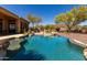 Inviting backyard pool with stone accents and mature desert trees at 42145 N Fairgreen Ct, Anthem, AZ 85086