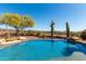 Stunning backyard featuring a sparkling pool and desert landscaping at 42145 N Fairgreen Ct, Anthem, AZ 85086