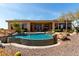 A beautiful pool is surrounded by desert landscaping, boulders, and an outdoor living space at 42145 N Fairgreen Ct, Anthem, AZ 85086