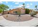 Corner lot property showcasing desert landscaping with rock accents and mature trees enhancing its curb appeal at 4353 E Desert Wind Dr, Phoenix, AZ 85044