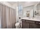 Bright bathroom featuring a vanity with modern fixtures, a toilet, and a shower with neutral-colored curtain at 4803 S Ferric --, Mesa, AZ 85212