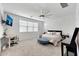 Bright bedroom with a ceiling fan, carpet, modern furniture, a bench, and a home office setup at 4803 S Ferric --, Mesa, AZ 85212