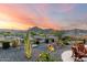 Desert landscaping and mountain views highlight this backyard at dusk at 4946 N 210Th Ave, Buckeye, AZ 85396