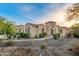 Attractive single-story home boasts beautiful desert landscaping, an arched entryway and manicured shrubs at 4946 N 210Th Ave, Buckeye, AZ 85396