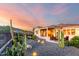 Stunning exterior of home with desert landscaping and covered patio at sunset at 4946 N 210Th Ave, Buckeye, AZ 85396