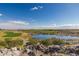 Scenic golf course view showcasing a lake, lush greens, and a beautiful blue sky at 4946 N 210Th Ave, Buckeye, AZ 85396