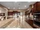 Beautiful kitchen featuring an oversized granite island, stainless steel appliances, and dark wood cabinets at 4946 N 210Th Ave, Buckeye, AZ 85396