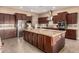 Spacious kitchen with stainless steel appliances, granite countertops, island, and ample dark wood cabinetry at 4946 N 210Th Ave, Buckeye, AZ 85396