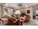Comfortable living room with leather furniture, ceiling fan, TV, and a sliding door to the outdoor living area at 4946 N 210Th Ave, Buckeye, AZ 85396