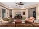 Cozy living room featuring leather seating, patterned armchairs, and a media center under a ceiling fan at 4946 N 210Th Ave, Buckeye, AZ 85396