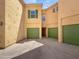 Exterior view of the building with green garage doors and a beige colored facade at 5015 E Cheyenne Dr # 14, Phoenix, AZ 85044