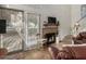 Cozy living room features a brick fireplace, tile flooring, and natural light from the large window at 602 N May St # 65, Mesa, AZ 85201
