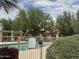 Community pool area featuring a safety fence, with a pergola and lush greenery in the background at 602 N May St # 65, Mesa, AZ 85201
