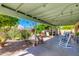 Back patio with large covered patio, chairs, and blooming landscape at 6031 E Inglewood St, Mesa, AZ 85205